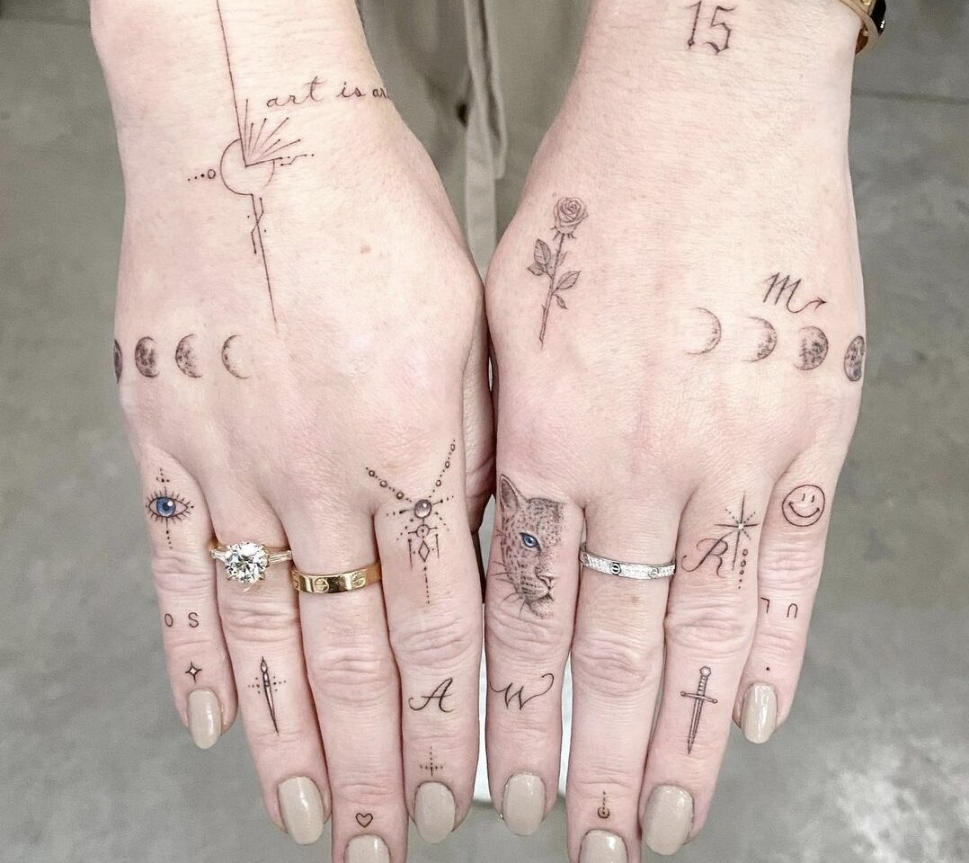 Dłonie ozdobione wieloma małymi tatuażami