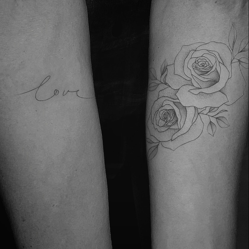 Tatuaż w stylu fine line, słowo love i róża